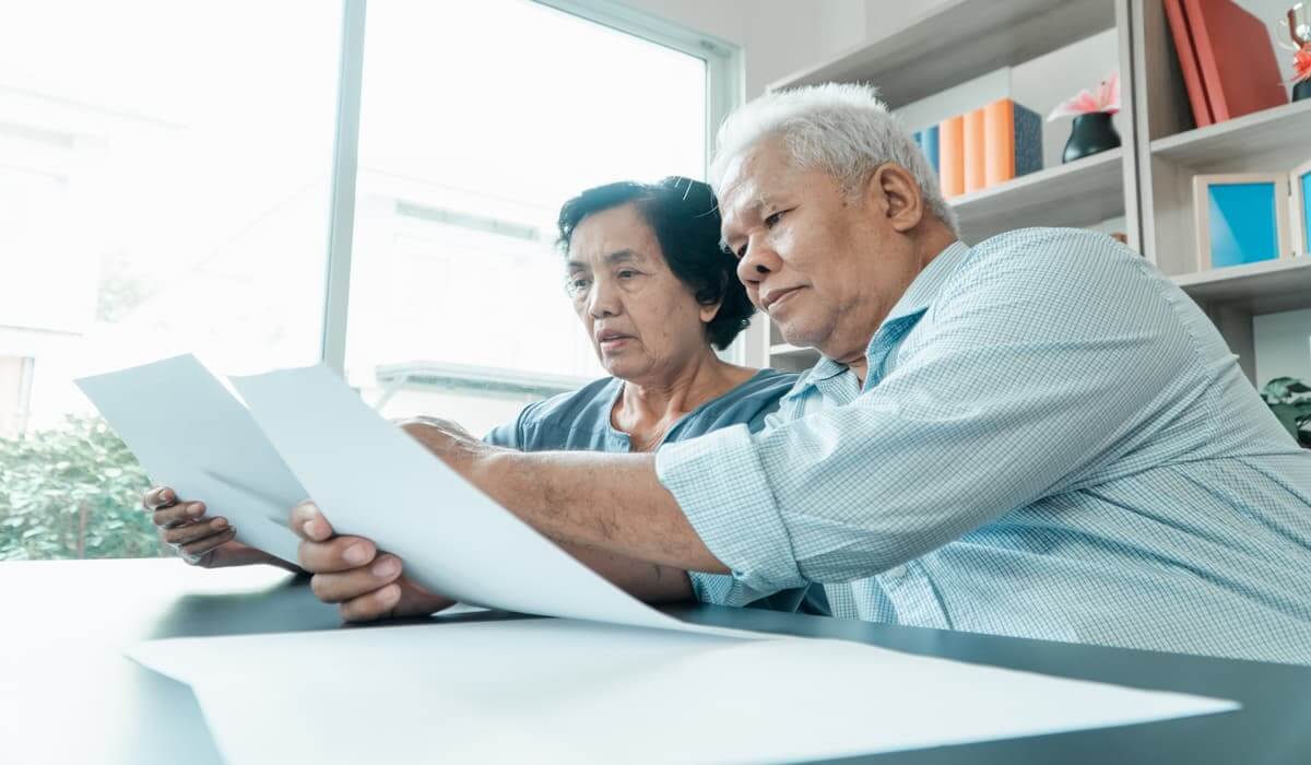 1099 r mail dates elderly couple looking at tax documents